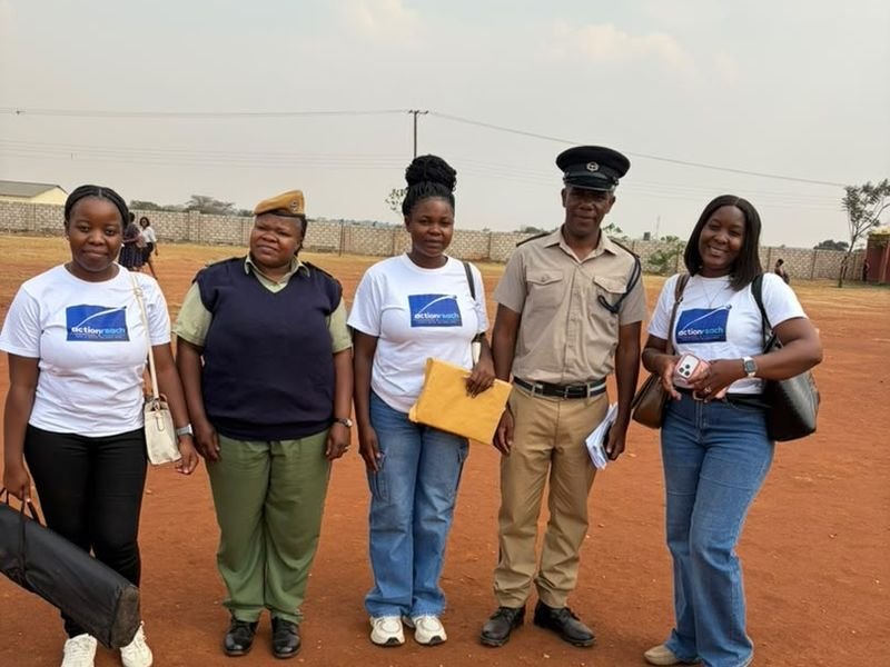 Actionreach team members standing outdoors with a uniformed officer